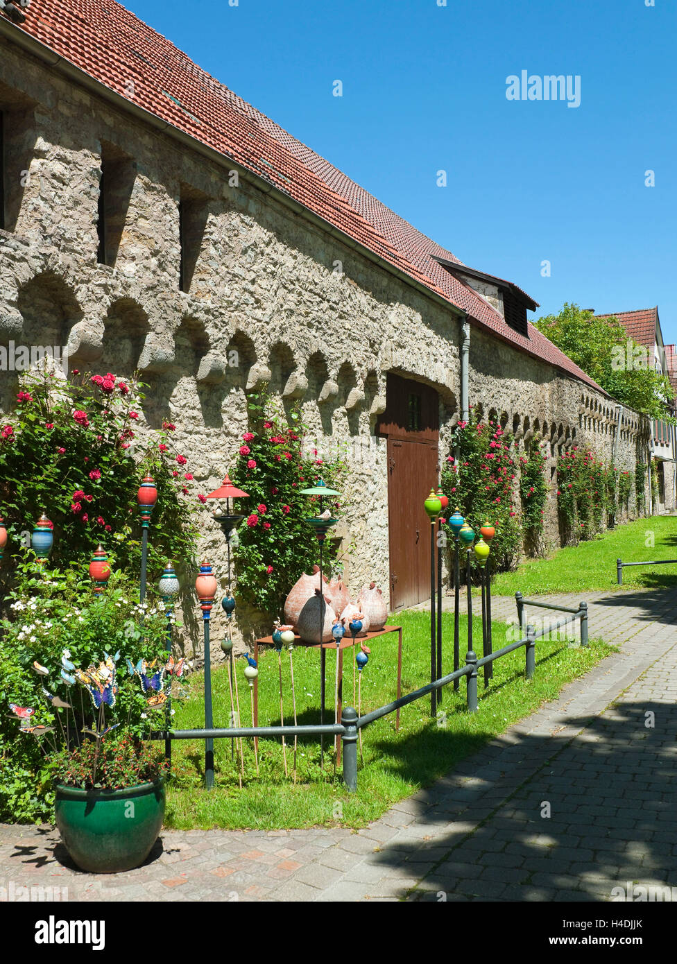 Germania, Baden-Württemberg, Möckmühl nella caccia, la parete della città con decorazioni floreali e Gartendeko Foto Stock