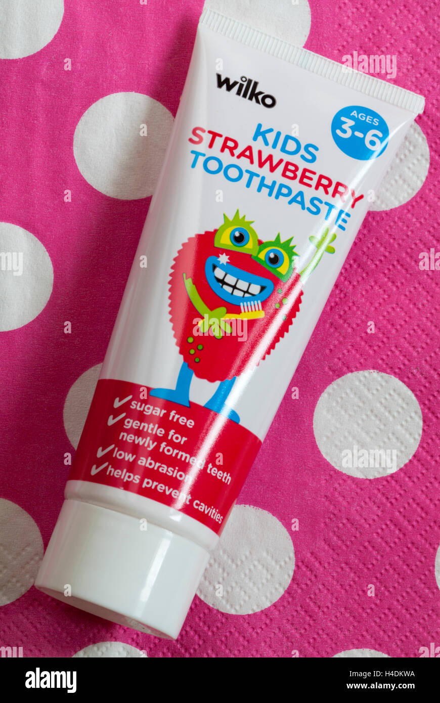 Tubo di Wilko kids dentifricio alla fragola per bambini di età compresa tra 3 e 6 a pois rosa sullo sfondo Foto Stock