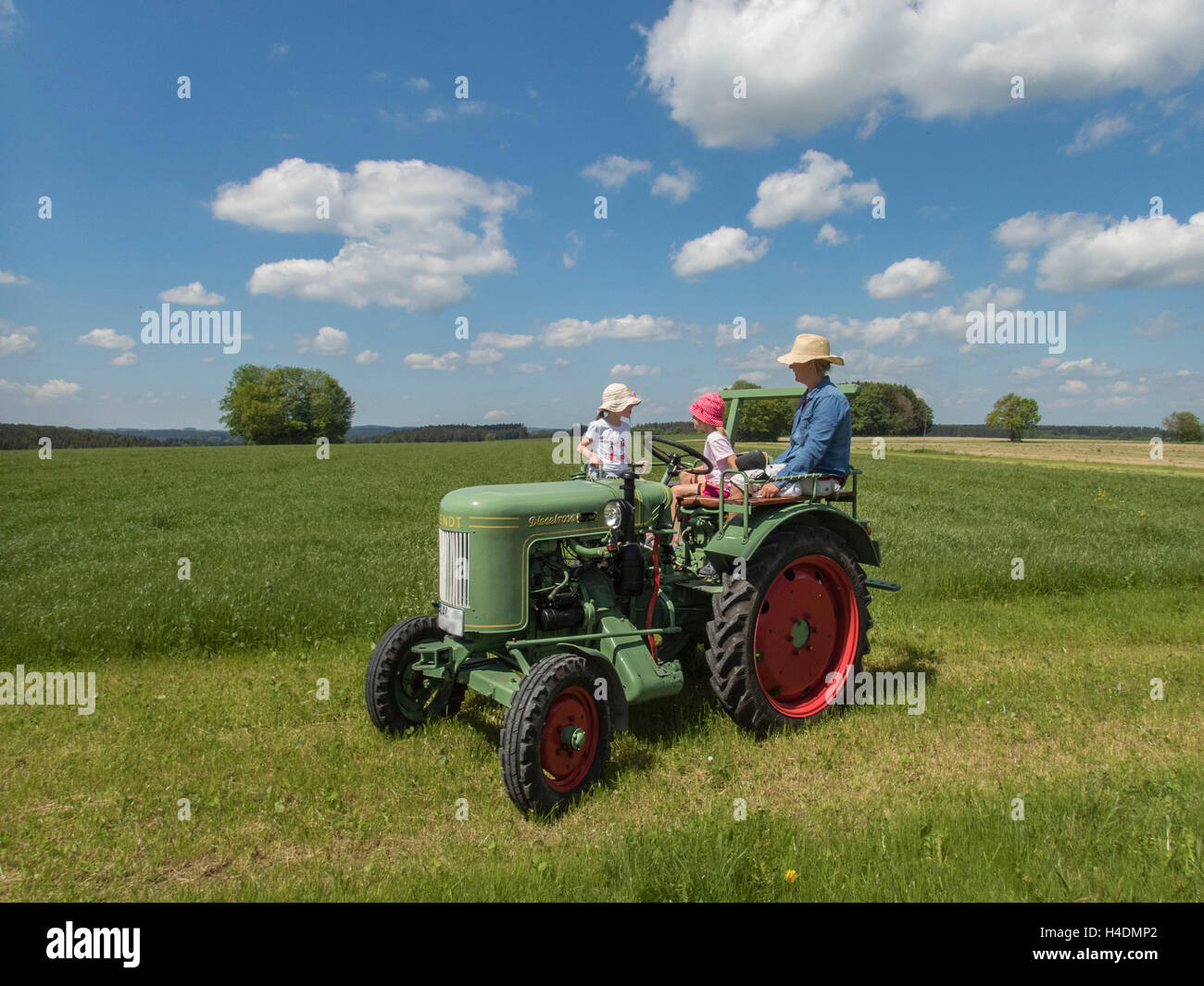 Gita di famiglia durante il fine settimana il trattore, prato, nuvole, bavaresi, molla Foto Stock