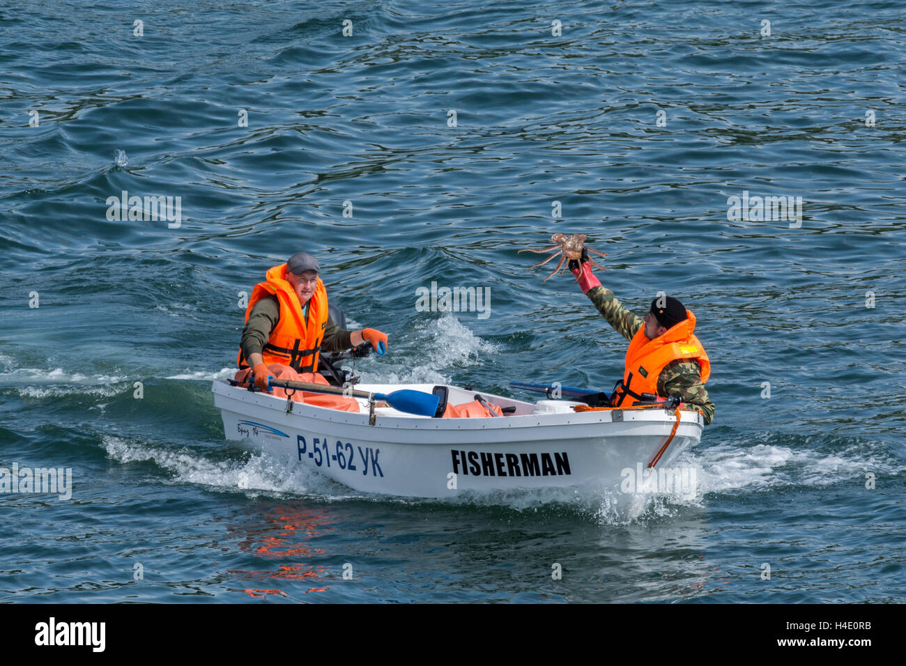 Russia, Kamchatka Krai, Petropavlovsk Kamchatsky (Pietro e Paolo). Pescatore in Avancha Bay, tenendo in mano il re granchio. Foto Stock