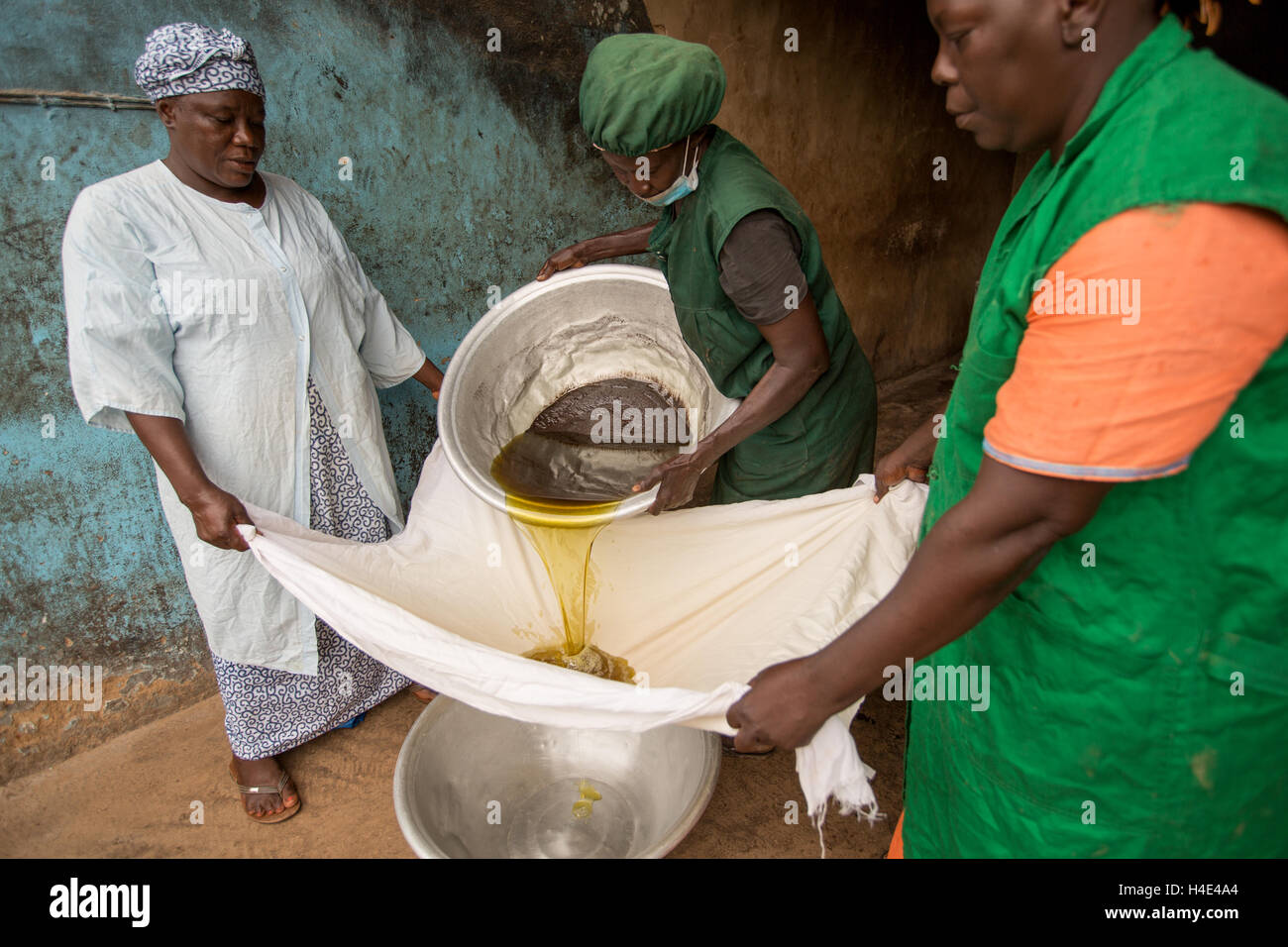 Filtro dipendenti appena elaborati) olio di karité ad un commercio equo impianto di produzione in Réo, Burkina Faso, Africa occidentale. Foto Stock
