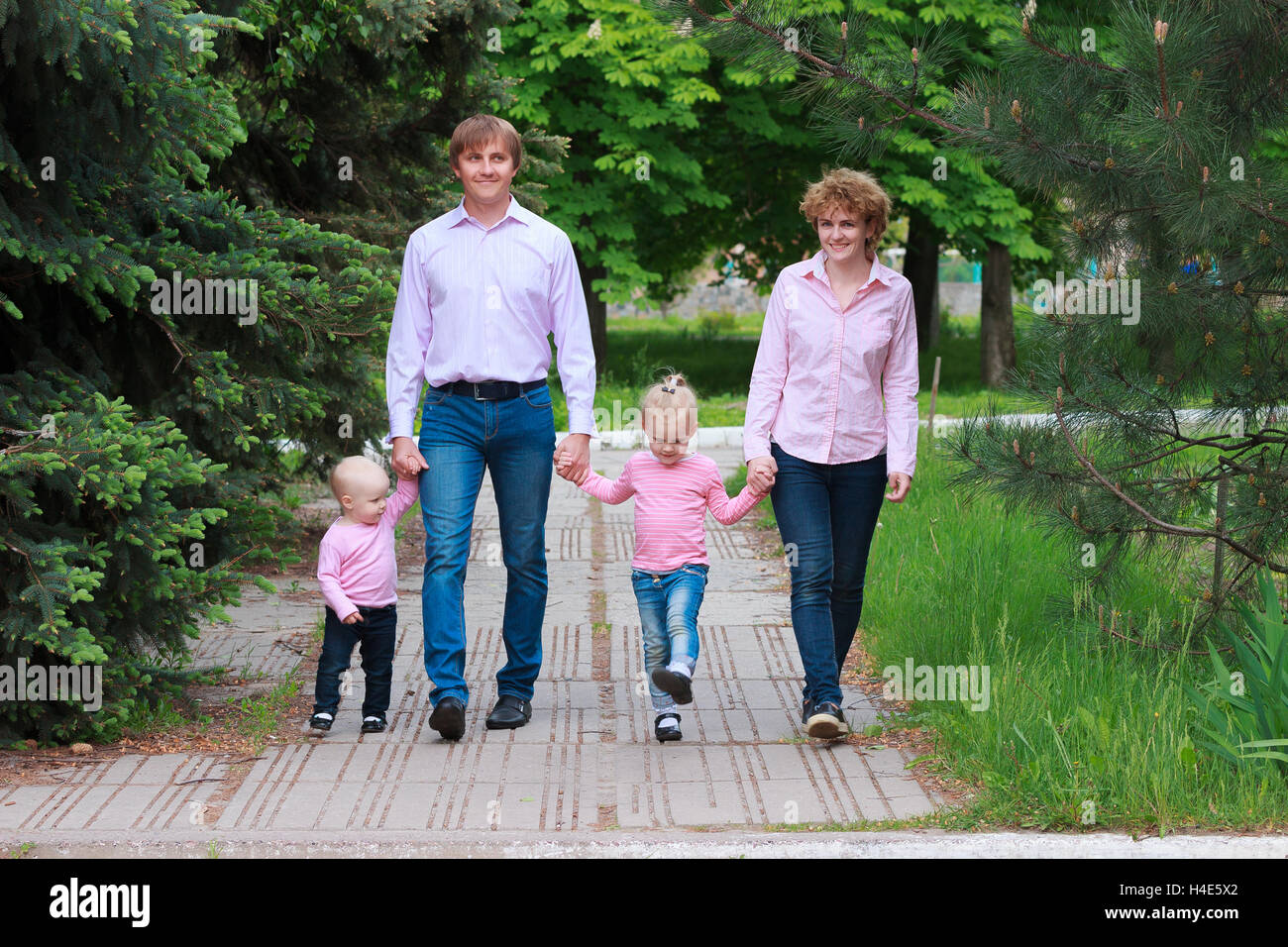 Felice giovane famiglia di trascorrere del tempo insieme al di fuori Foto Stock