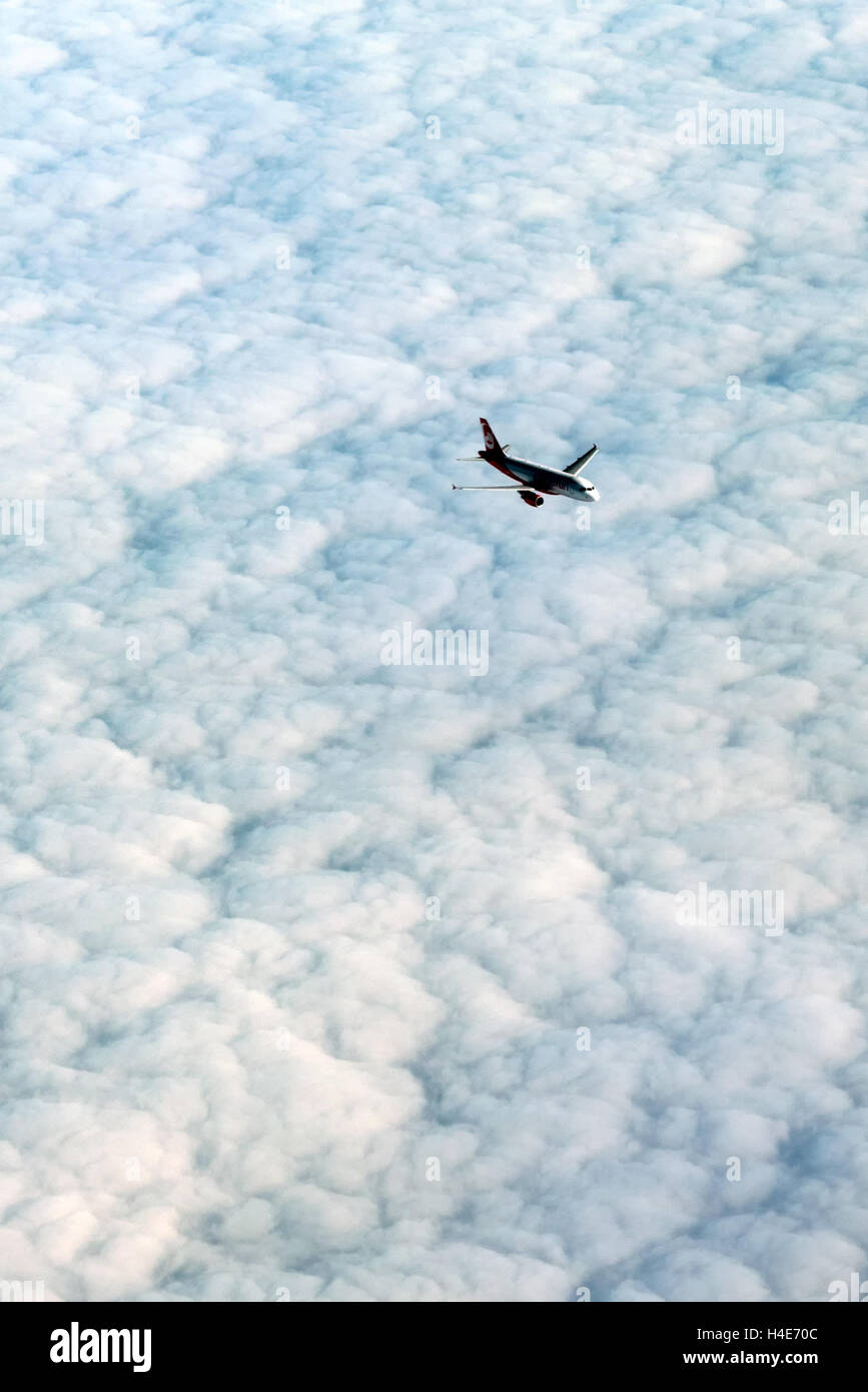 Vista da sopra di un aeroplano che vola al di sopra di un denso strato di cloud Foto Stock