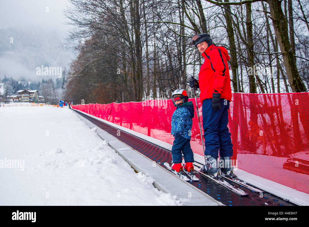 Padre insegnamento sci felice del suo piccolo figlio durante una vacanza invernale a Kitzbuhel,tirolese Alpi, Austria Foto Stock