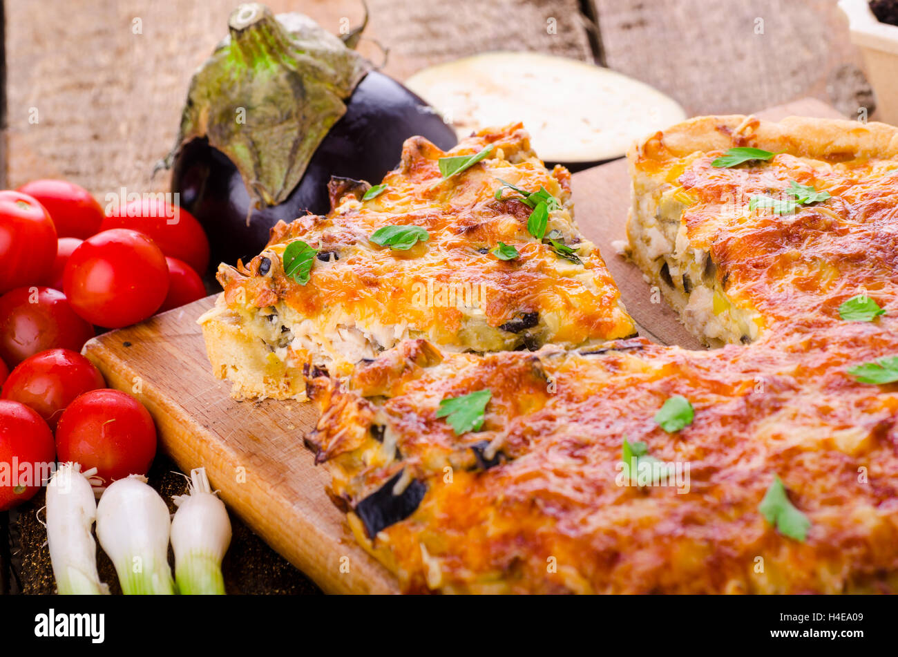 Il francese Quiche con melanzane, porri e cipollotti, immersa in una deliziosa panna e cotto al forno fino a quando non diventano croccanti Foto Stock