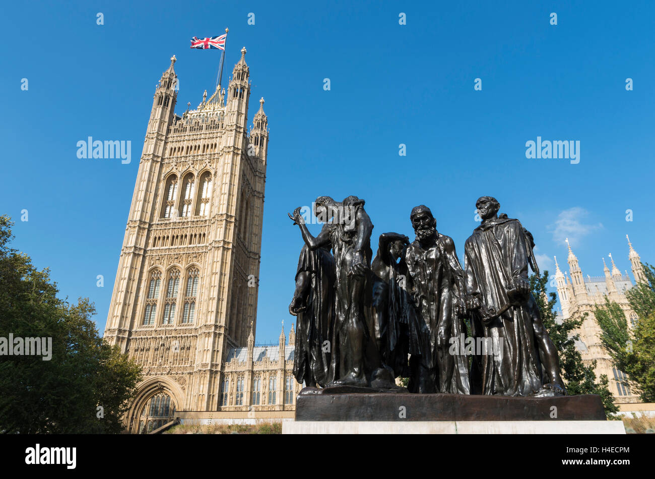 Vista di Victoria Torre del Palazzo del Parlamento e la scultura di Auguste Rodin 'i borghesi di Calais', London, Regno Unito Foto Stock