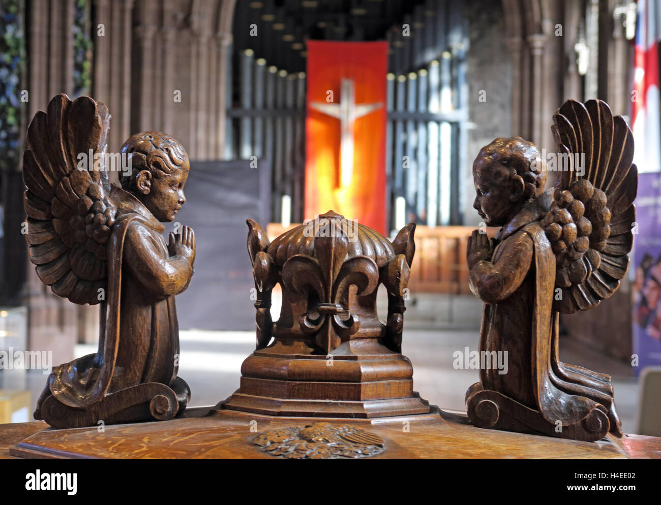 Crocifisso e un organo a canne dietro font angeli,Cattedrale di Manchester, Inghilterra, Regno Unito Foto Stock