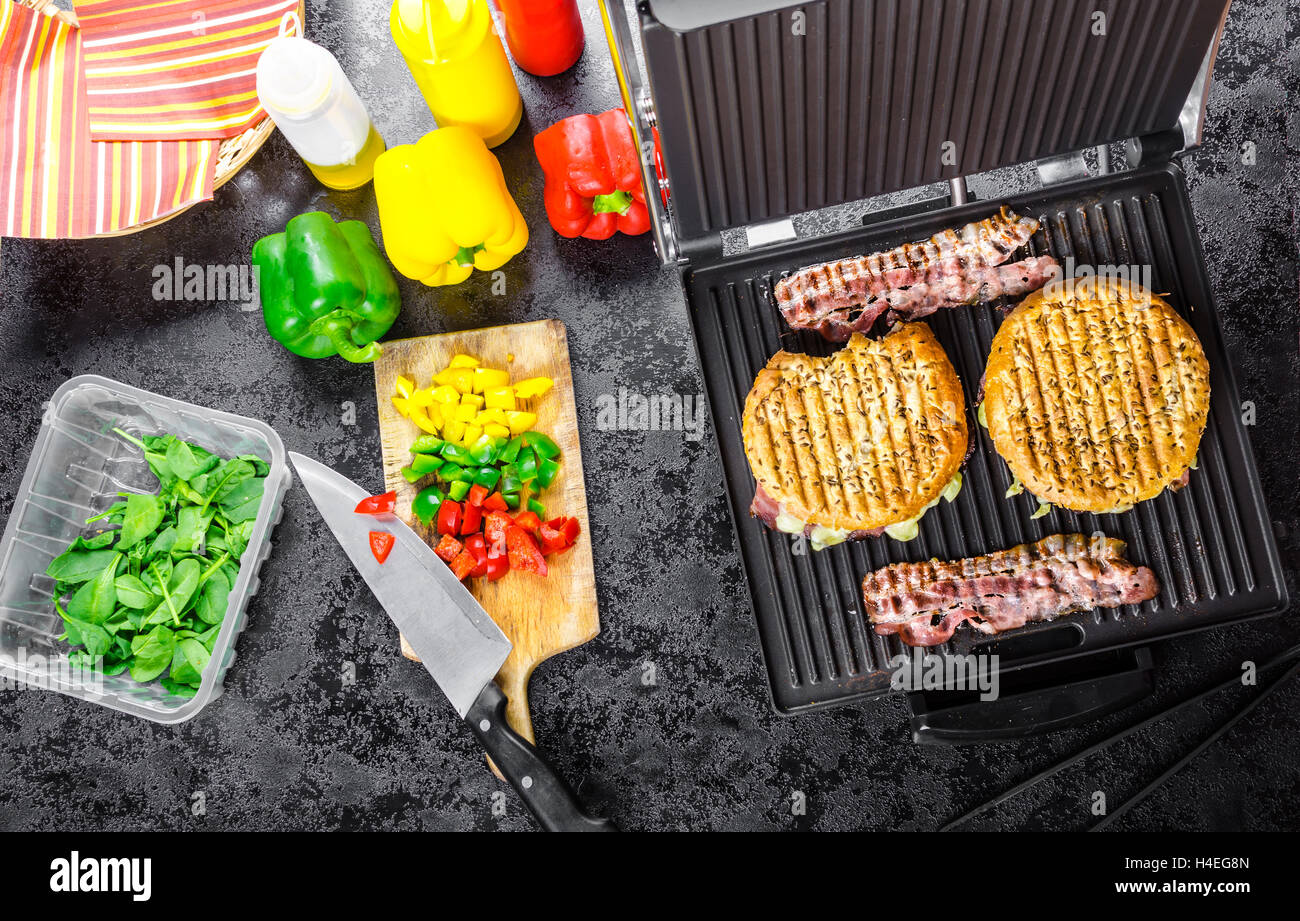 Fare panini, panini shop, ketchup, senape, olio d'oliva Bottiglia, erbe, tovaglioli e preparare vegetale Foto Stock