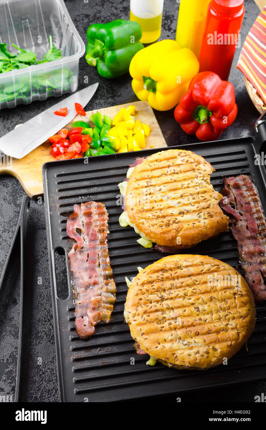 Fare panini, panini shop, ketchup, senape, olio d'oliva Bottiglia, erbe, tovaglioli e preparare vegetale Foto Stock