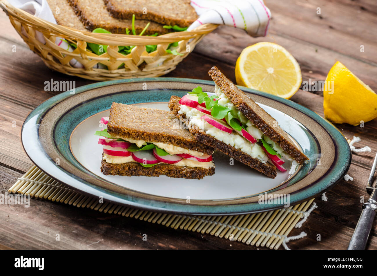 Snack sani - pane integrale con uovo-crema diffusione e verdure fresche foglie di rucola e ravanelli Foto Stock