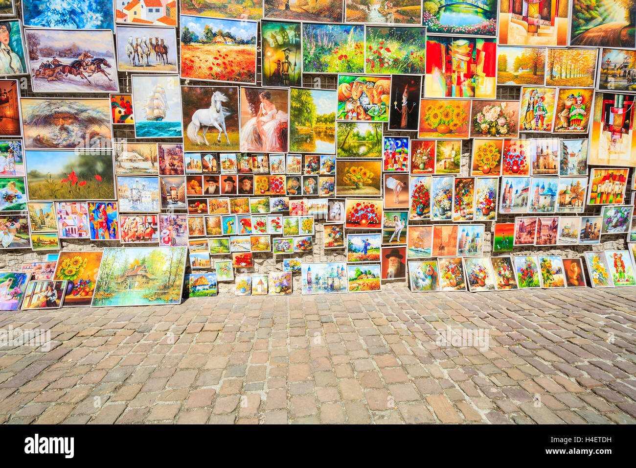 Cracovia in Polonia - 4 Maggio 2014: Dipinti in vendita appendere su una parete nella città vecchia di Cracovia. Più di dieci milioni di turisti visitano la città ogni anno. Foto Stock