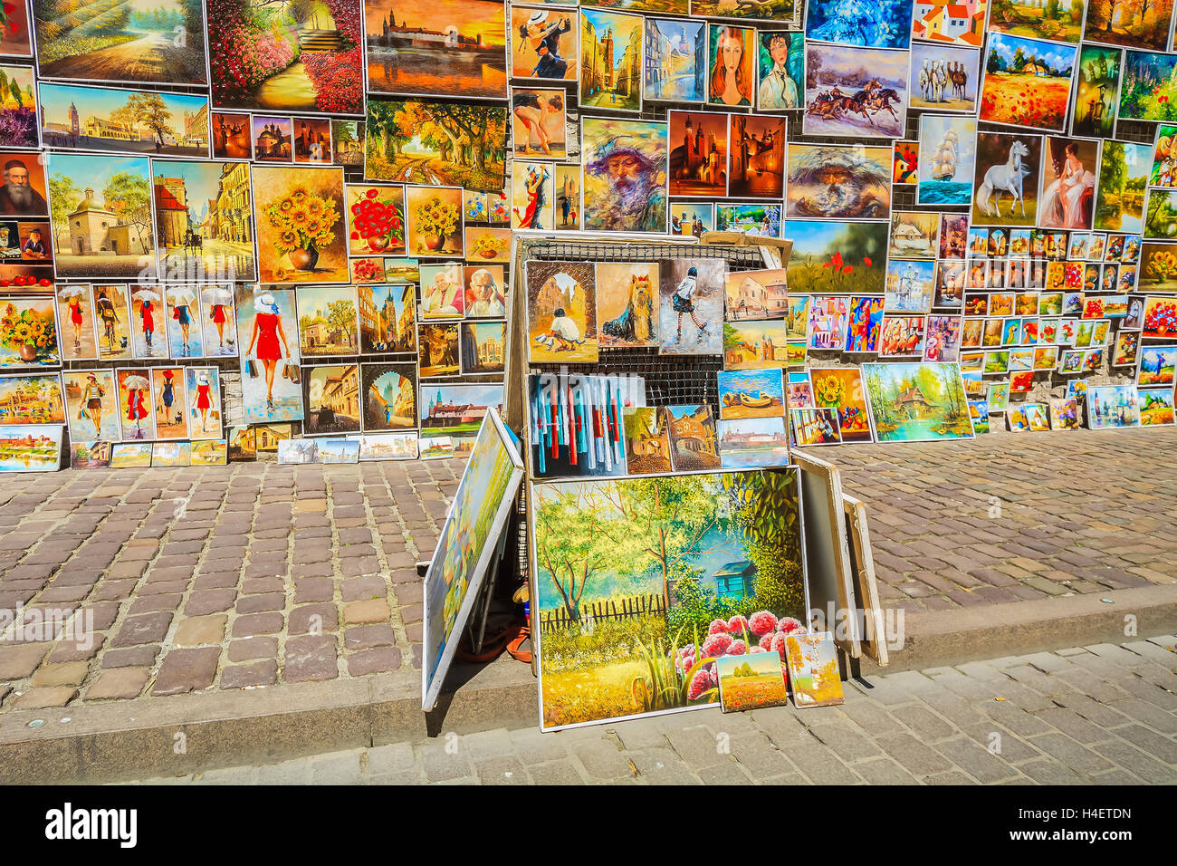 Cracovia in Polonia - 4 Maggio 2014: Dipinti in vendita appendere su una parete nella città vecchia di Cracovia. Più di dieci milioni di turisti visitano la città ogni anno. Foto Stock