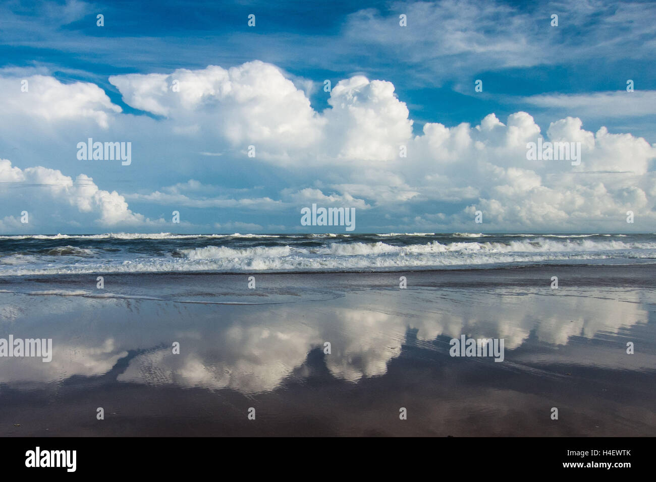 Puffy nuvole e cielo blu riflettere nella sabbia bagnata dell'Oceano Atlantico spiaggia dell'Outer Banks OBX nazionale riva del mare Foto Stock