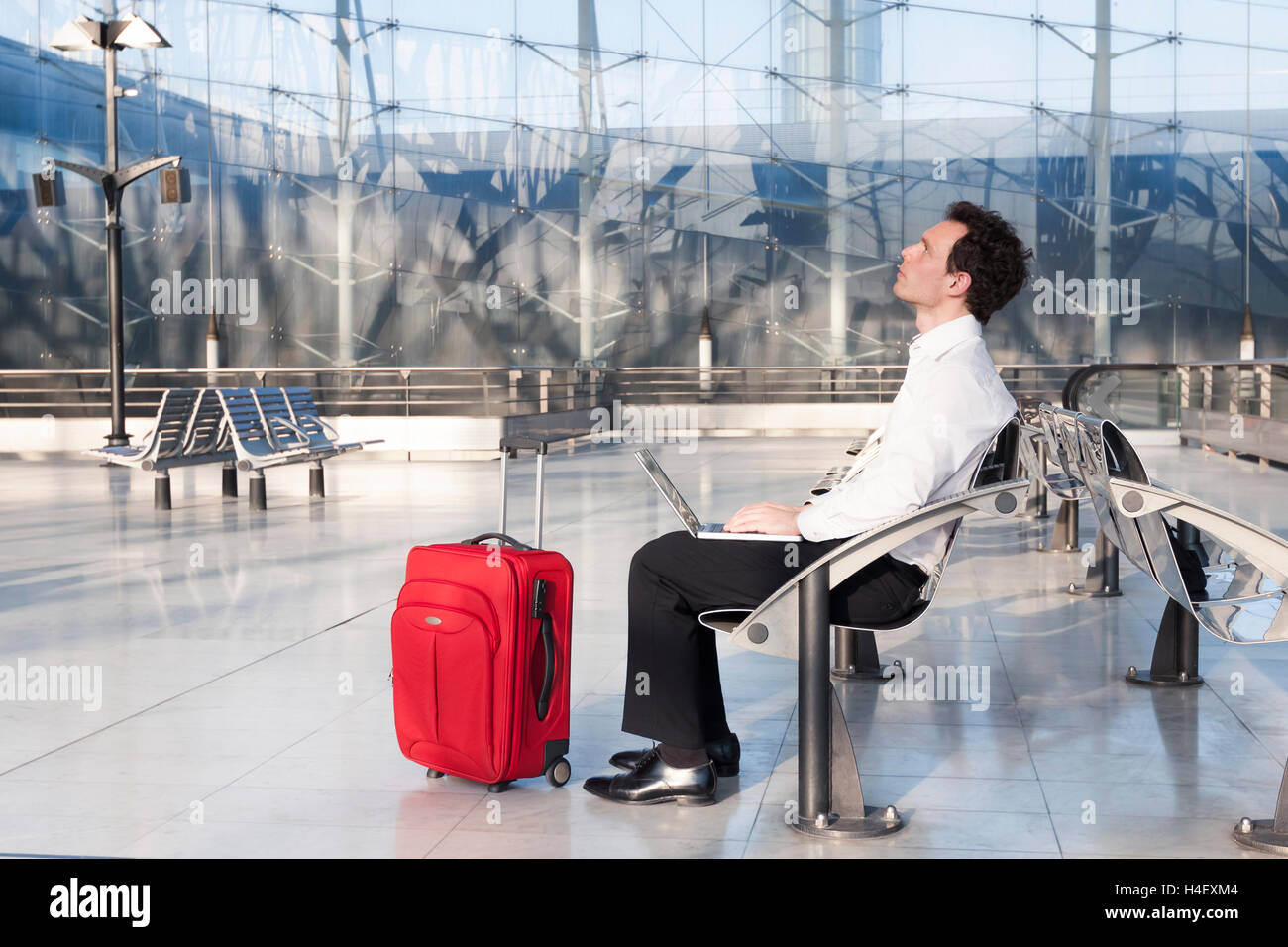 Imprenditore immaginando le idee durante l'attesa in aeroporto Foto Stock