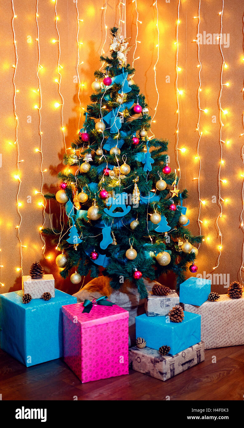 Natale Room interior design, albero di Natale decorato da luci presenta doni giocattoli, candele e Garland l'illuminazione in interni Foto Stock
