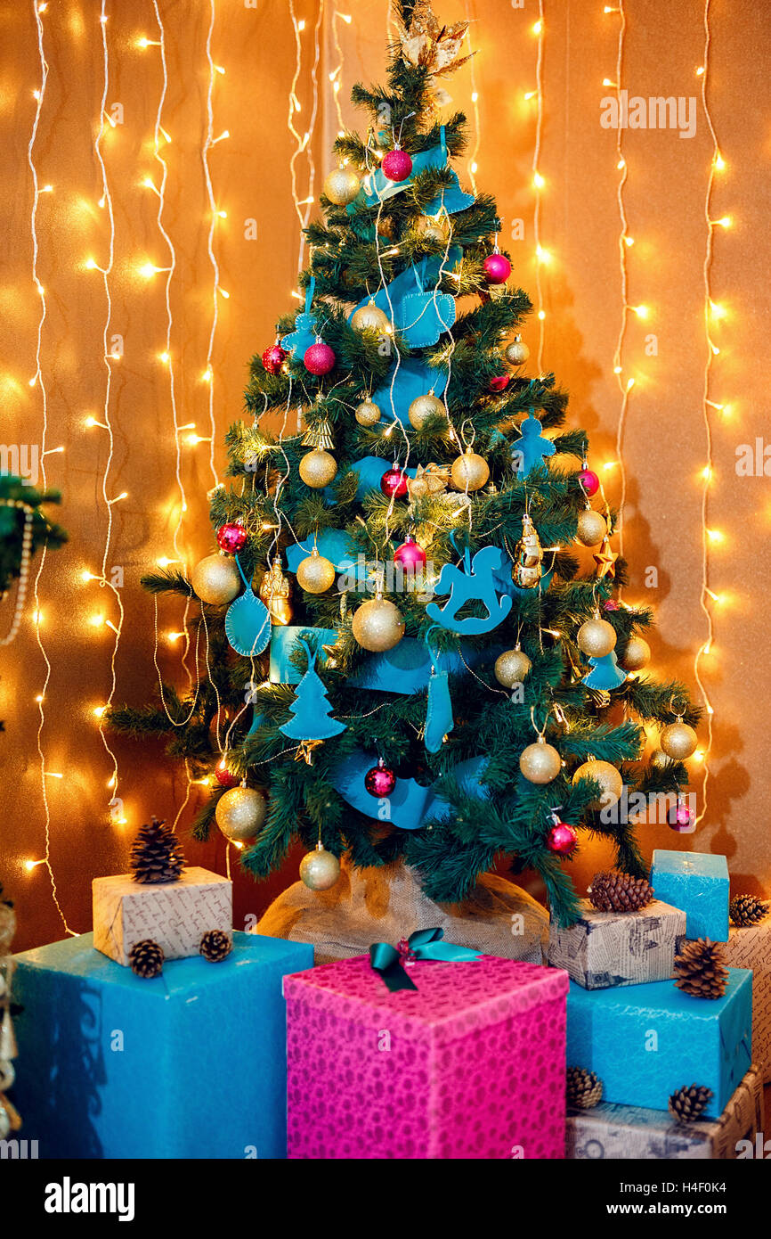 Natale Room interior design, albero di Natale decorato da luci presenta doni giocattoli, candele e Garland l'illuminazione in interni Foto Stock