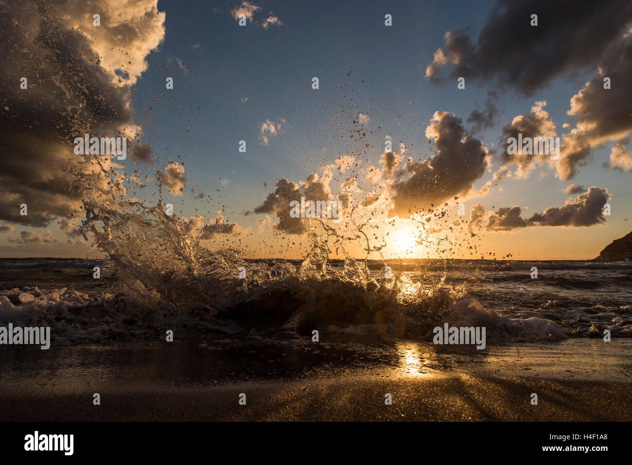 Onde che si infrangono sulla spiaggia al tramonto, Porto Ferro, Sardegna, Italia Foto Stock