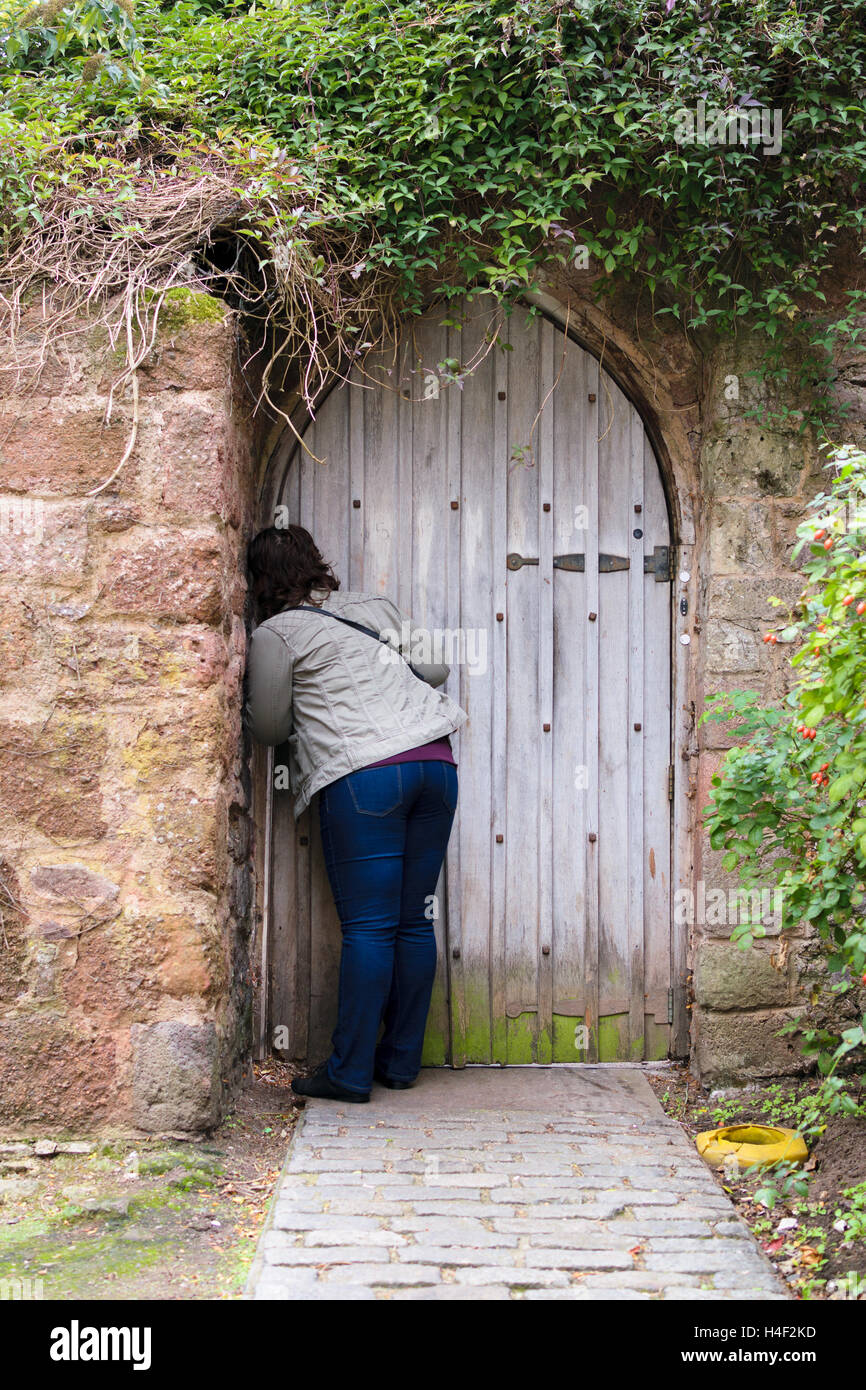 Exeter Devon, Inghilterra, Regno Unito - 30 Settembre 2016: persona non identificata apre una porta vicino al muro romano a Exeter, Regno Unito. Foto Stock