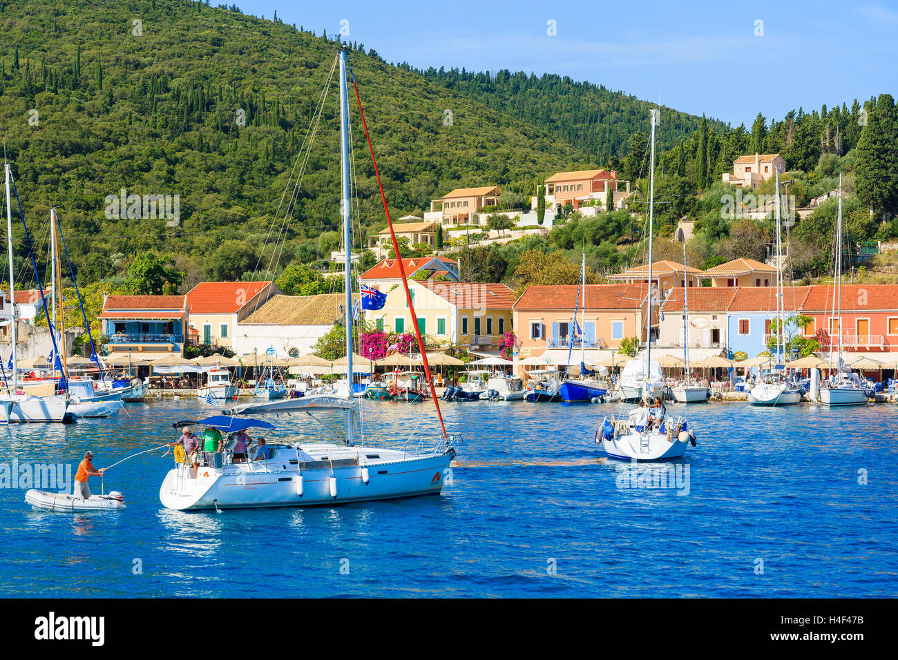 FISKARDO PORT, l'isola di Cefalonia, Grecia - Sep 19, 2014: Yacht barche sul blu del mare e la vista di Fiskardo villaggio di pescatori con la porta. Yachting è una delle attività più popolari su isole greche. Foto Stock