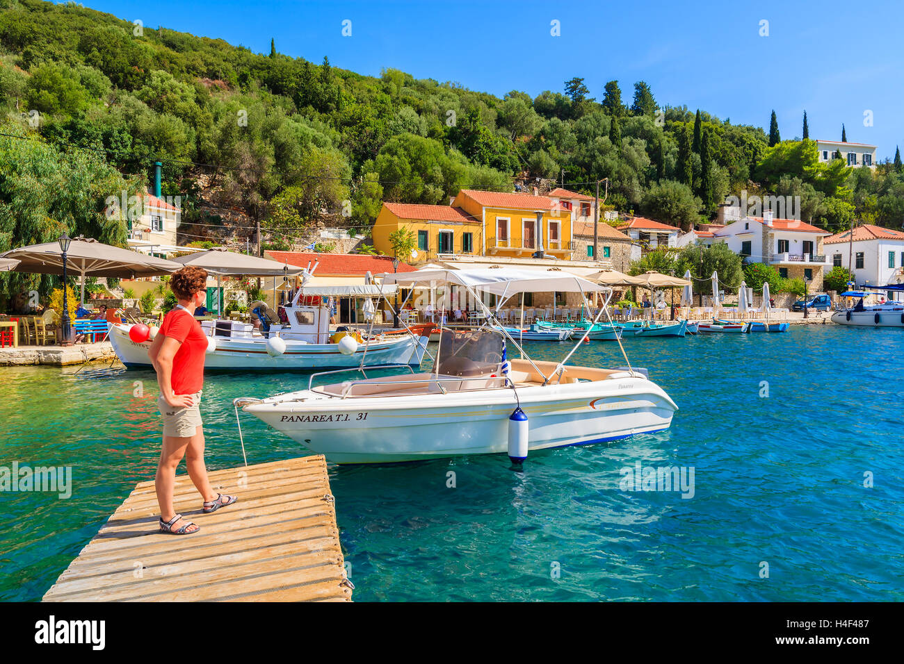 KIONI PORTA, Itaca isola - Sep 19, 2014: il giovane turista in piedi sul molo di legno in Kioni porta. La Grecia è molto popolare meta di vacanza in Europa. Foto Stock