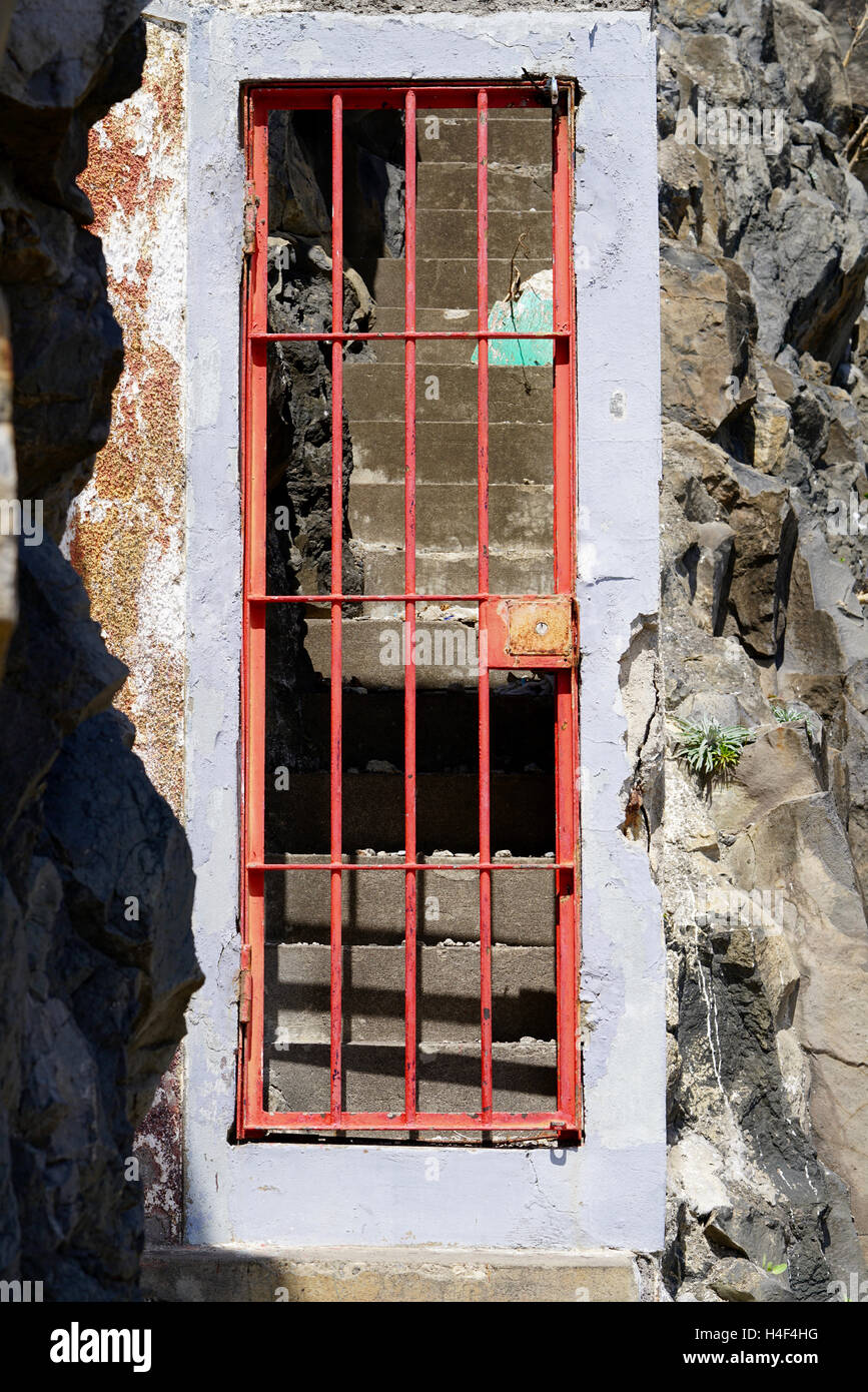Chiuso rosso morbosa porta di metallo, scale dietro Foto Stock