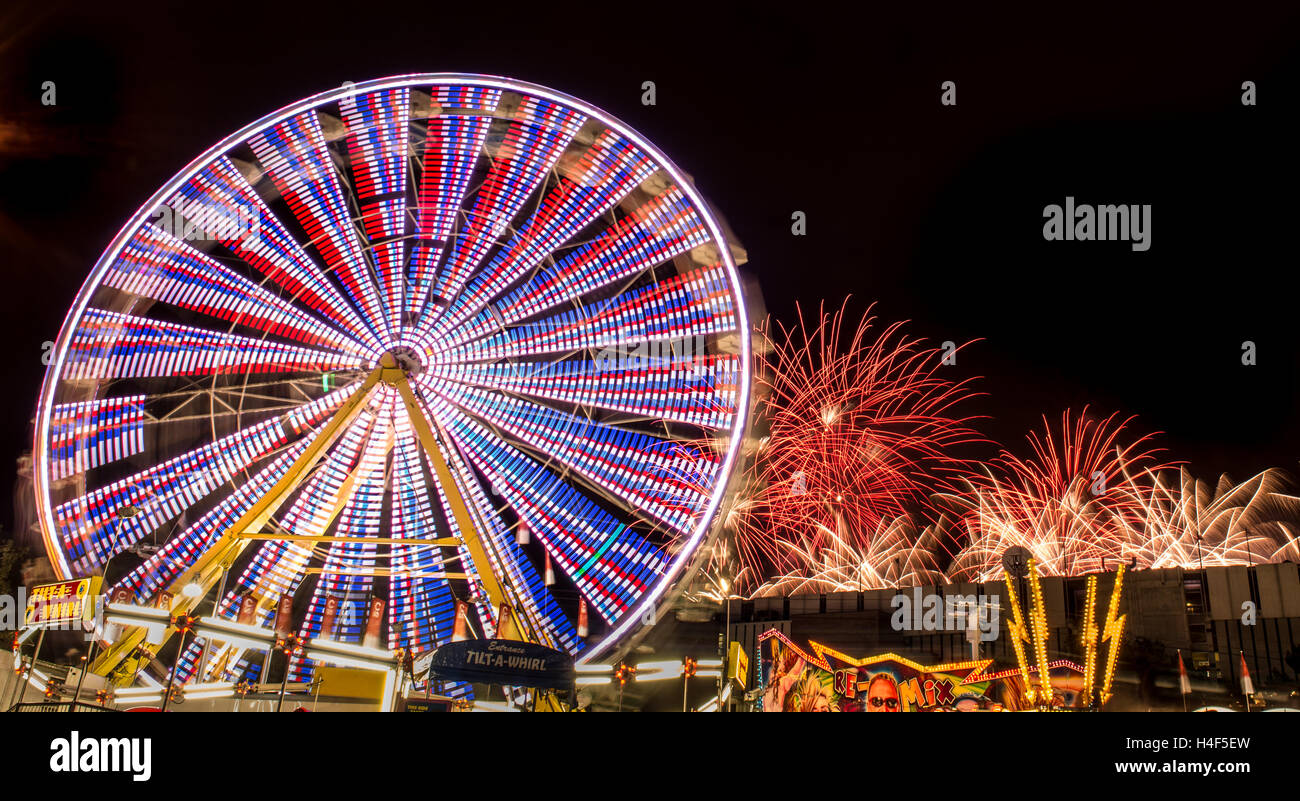 Fuochi d'artificio dietro un midway ruota panoramica Ferris giro in Calgary Stampede Foto Stock