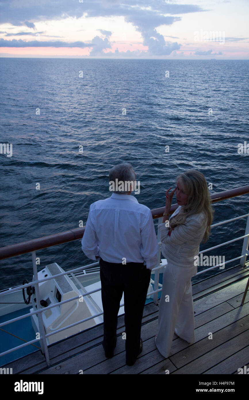 Un giovane osserva un avvicinamento tramonto dal ponte di Windstar Cruises vela-cruiser Wind Surf durante una crociera sul Baltico. Foto Stock