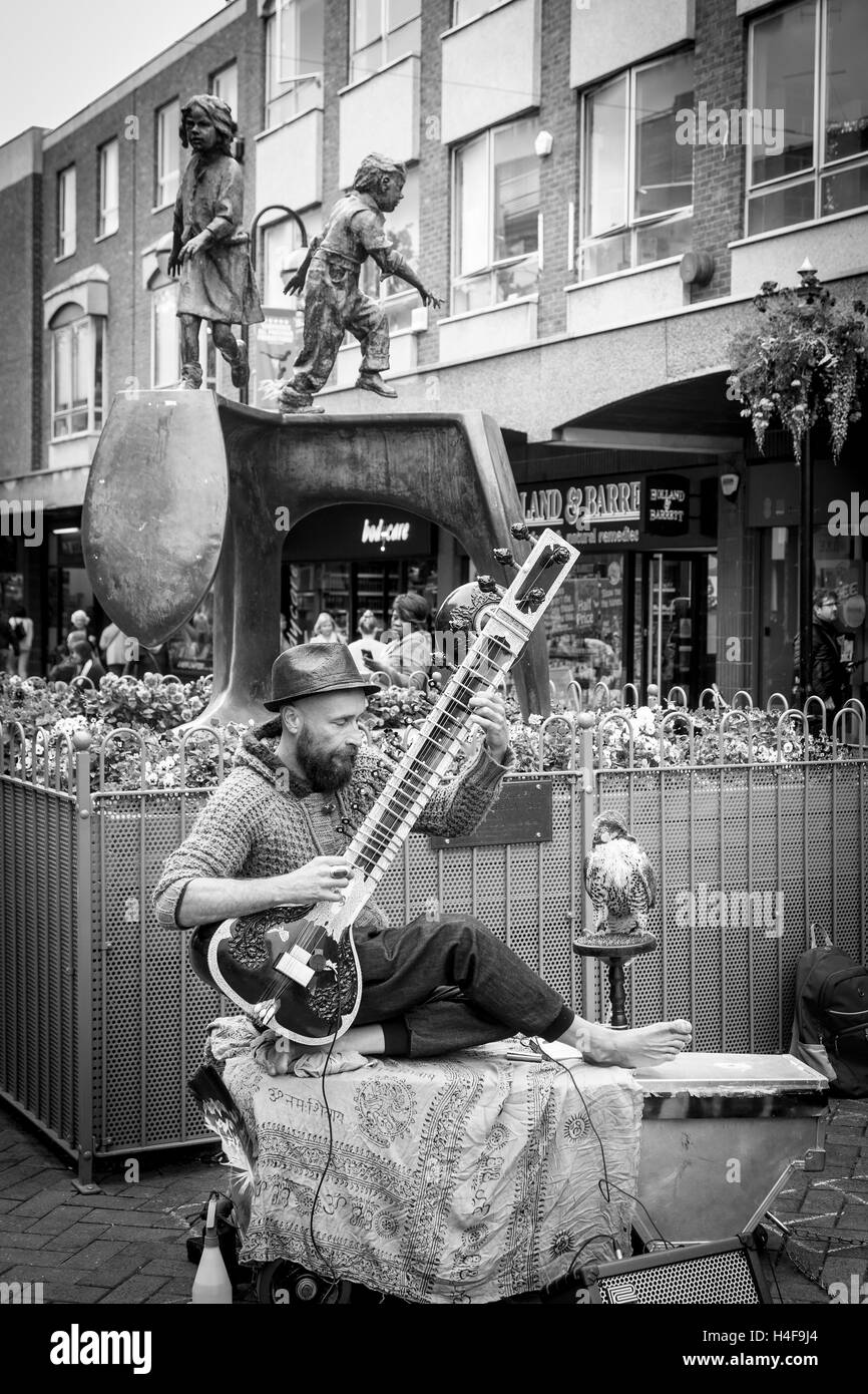 Buskers giocando un Grand Pro Tun Sitar un strumento indiano in Abington Street, centro di Northampton. Foto Stock