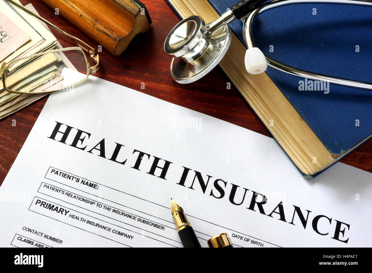 Assicurazione sanitaria privata su una superficie di legno con gli occhiali. Foto Stock