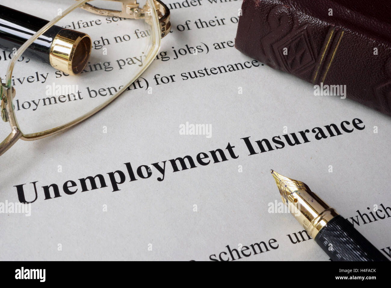 Assicurazione contro la disoccupazione concetto scritto su un foglio di carta. Foto Stock