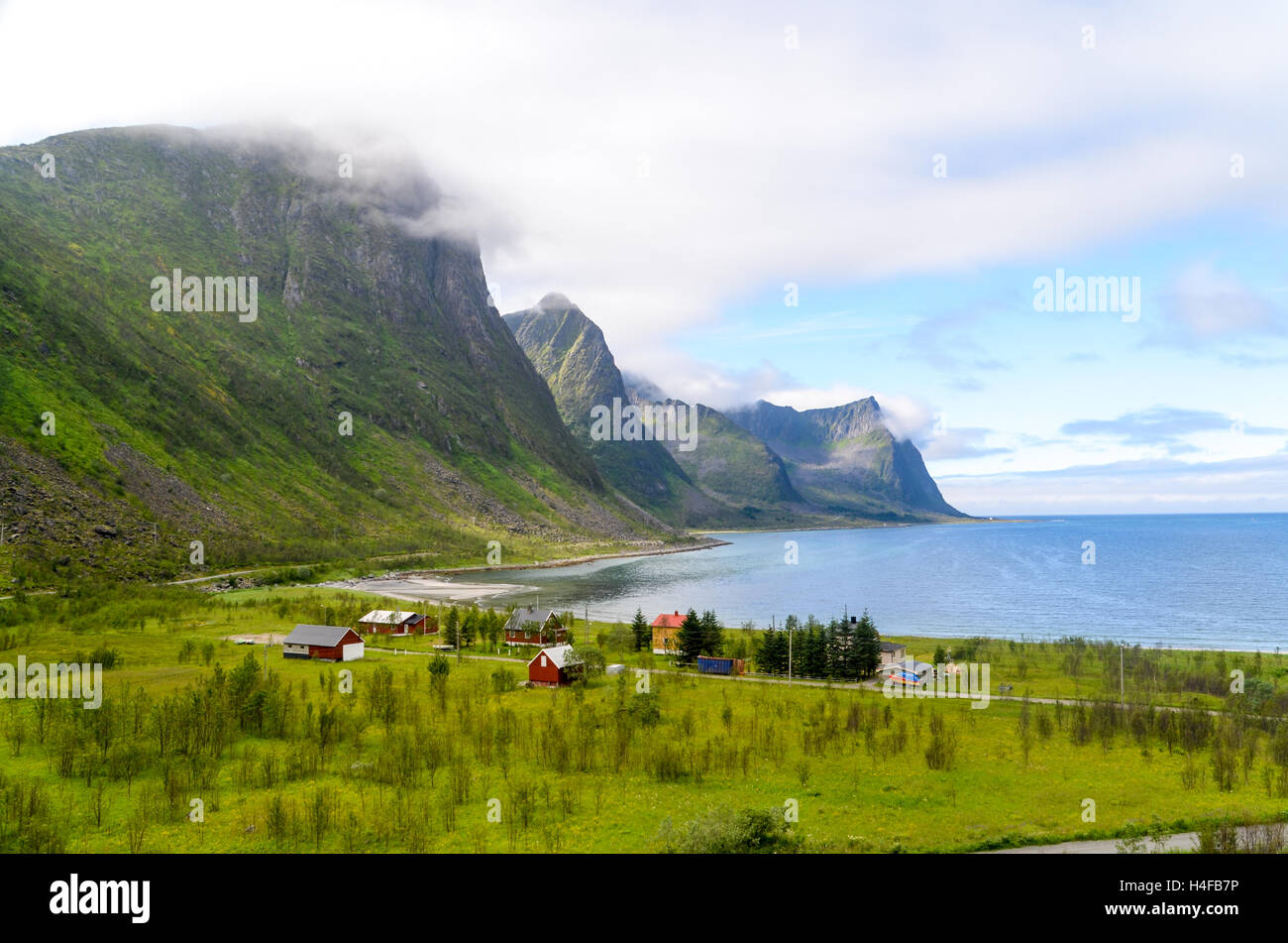 Nuvole prendendo il ruvido paesaggio di Senja, Norvegia, nei pressi di un villaggio Foto Stock