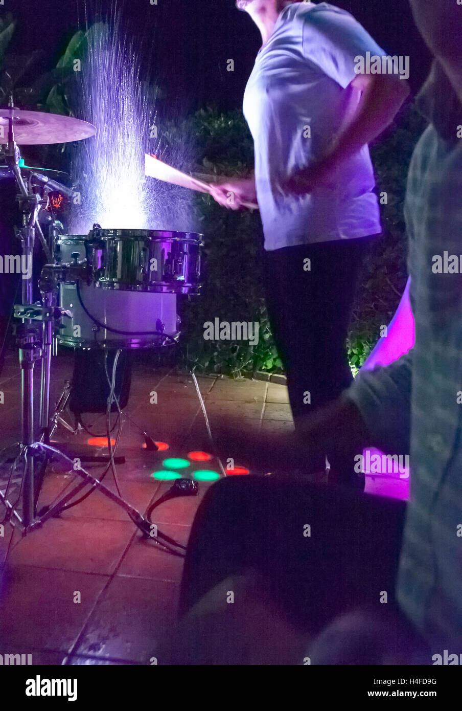 Il batterista di battitura e di schizzi tamburi di notte show. Slow motion shot Foto Stock