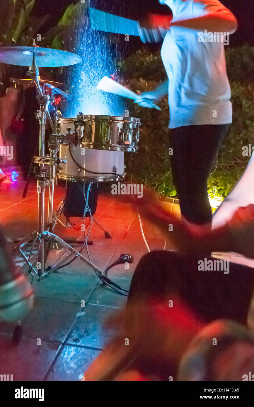 Il batterista di battitura e di schizzi tamburi di notte show. Slow motion shot Foto Stock