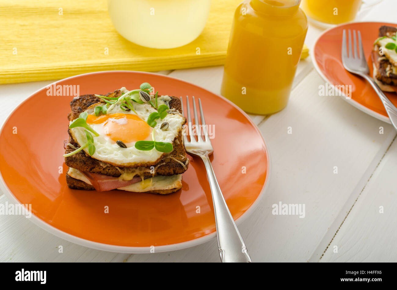 Cotta toast alla francese - Croque Madame, succo di arancia, girasole microgreens sulla parte superiore Foto Stock