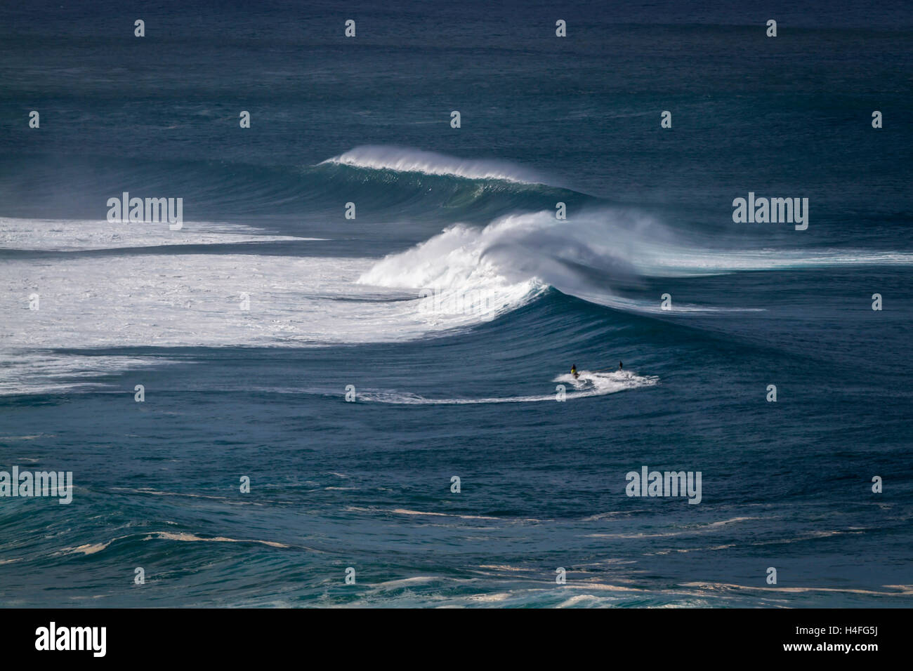 Una vista di surfers il traino in onde sulla North Shore di Oahu Hawaii Foto Stock