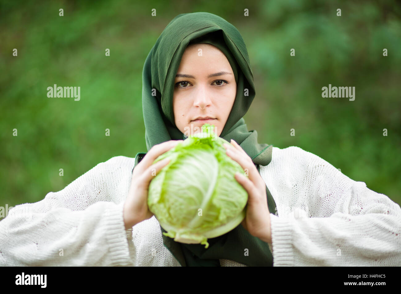 Vegano musulmano donna con velo tenendo un cavolo verza Foto Stock