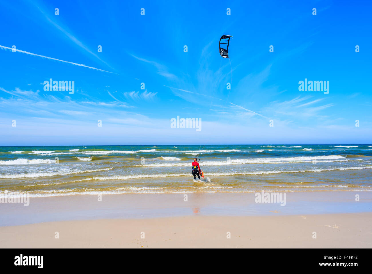Kitesurfer vela sul blu del mare con onde in Bialogora villaggio costiero, Mar Baltico, Polonia Foto Stock