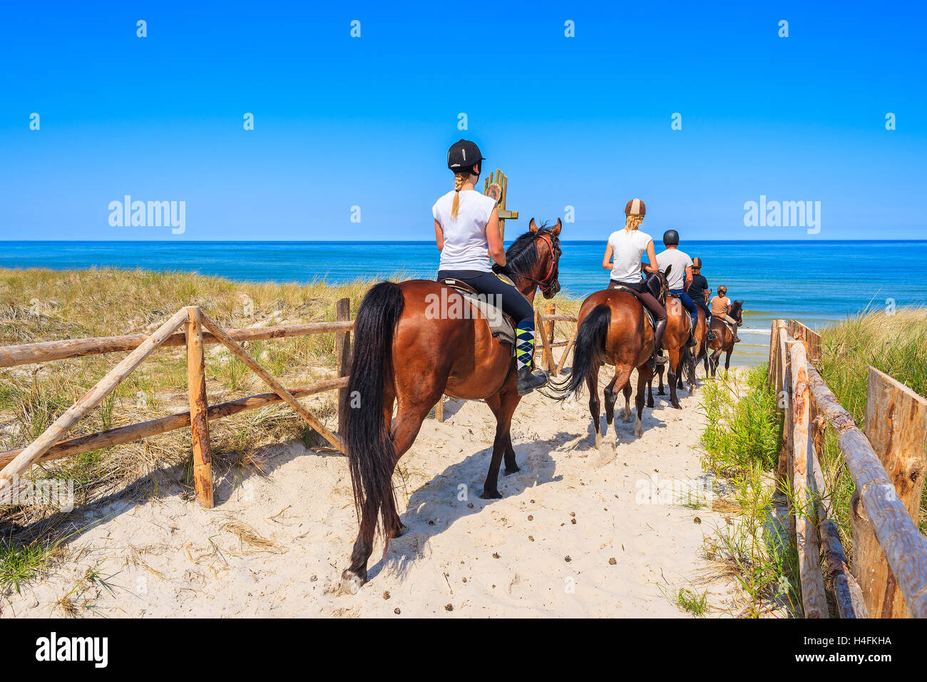 Le giovani donne a cavallo per la spiaggia sabbiosa in Lubiatowo villaggio costiero, Mar Baltico, Polonia Foto Stock