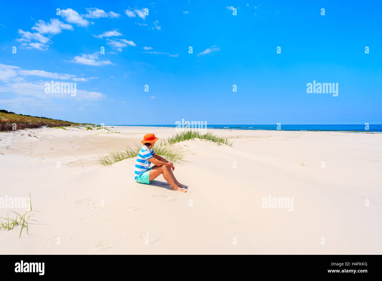 Giovane donna seduta turistica in sabbia sulla bella spiaggia di Lubiatowo villaggio costiero, Mar Baltico, Polonia Foto Stock
