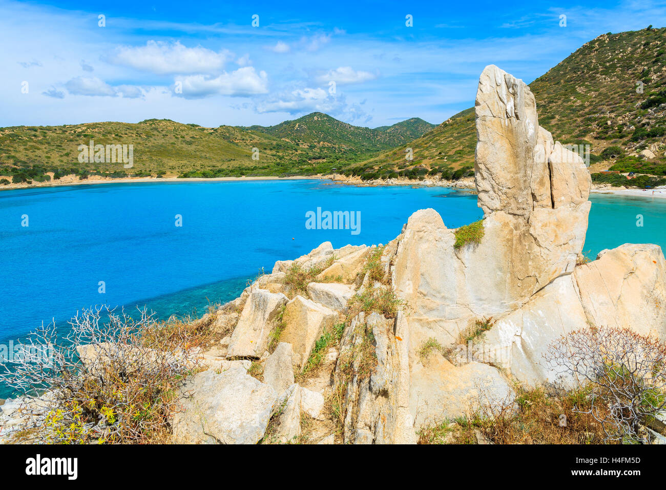 Formazione di roccia sulla cima di una collina e la vista di Punta Molentis baia con spiaggia bellissima isola di Sardegna, Italia Foto Stock