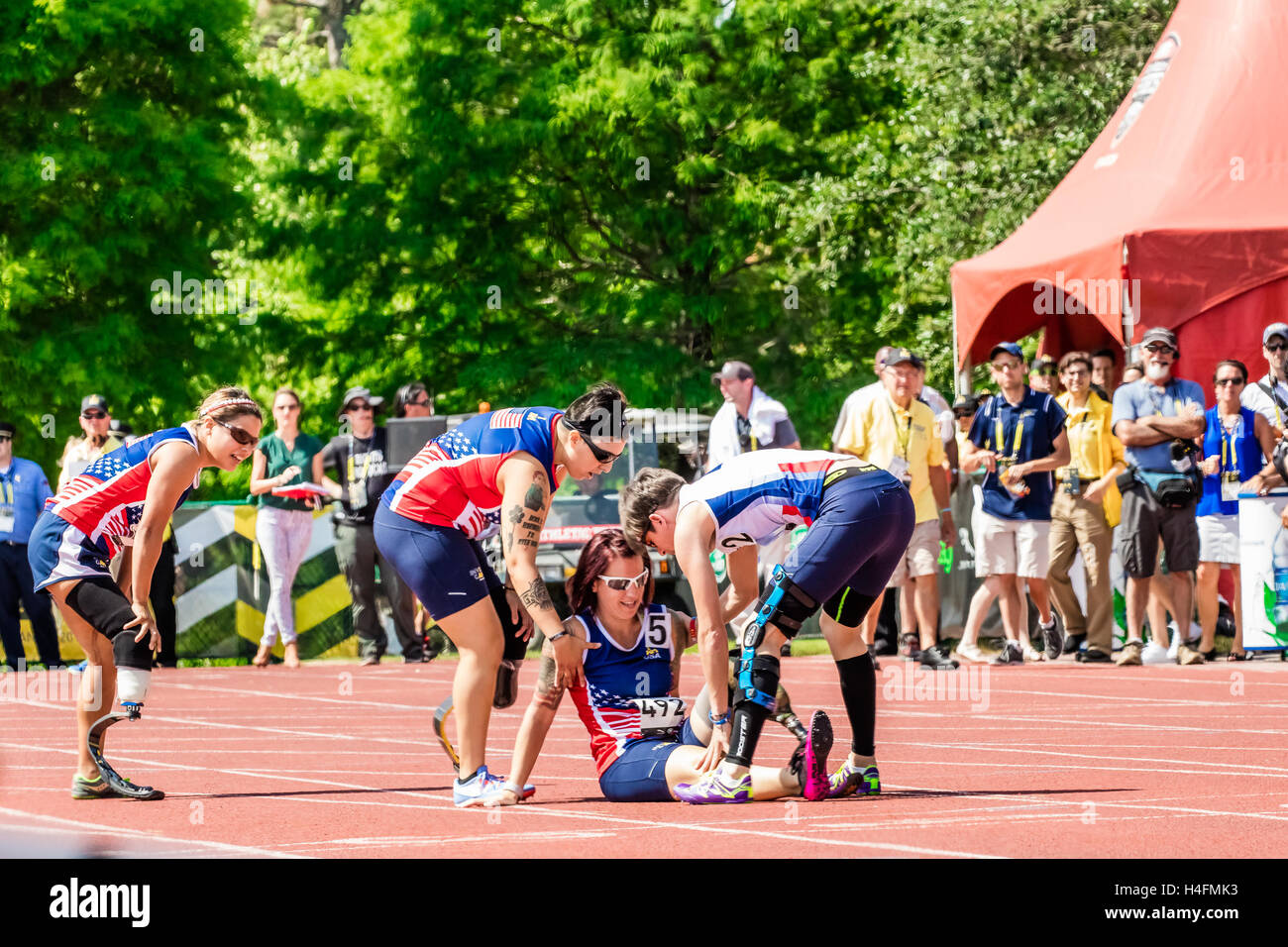 Marian Blot di Francia e Lauren Montoya degli Stati Uniti di controllare per assicurarsi che Sarah del timone della USA è andato a buon fine dopo che ella cadde durante la donna 200 Meter1 gara durante la Invictus giochi su 10 maggio 2016 presso la ESPN Wide World Sports Complex in Orlan Foto Stock