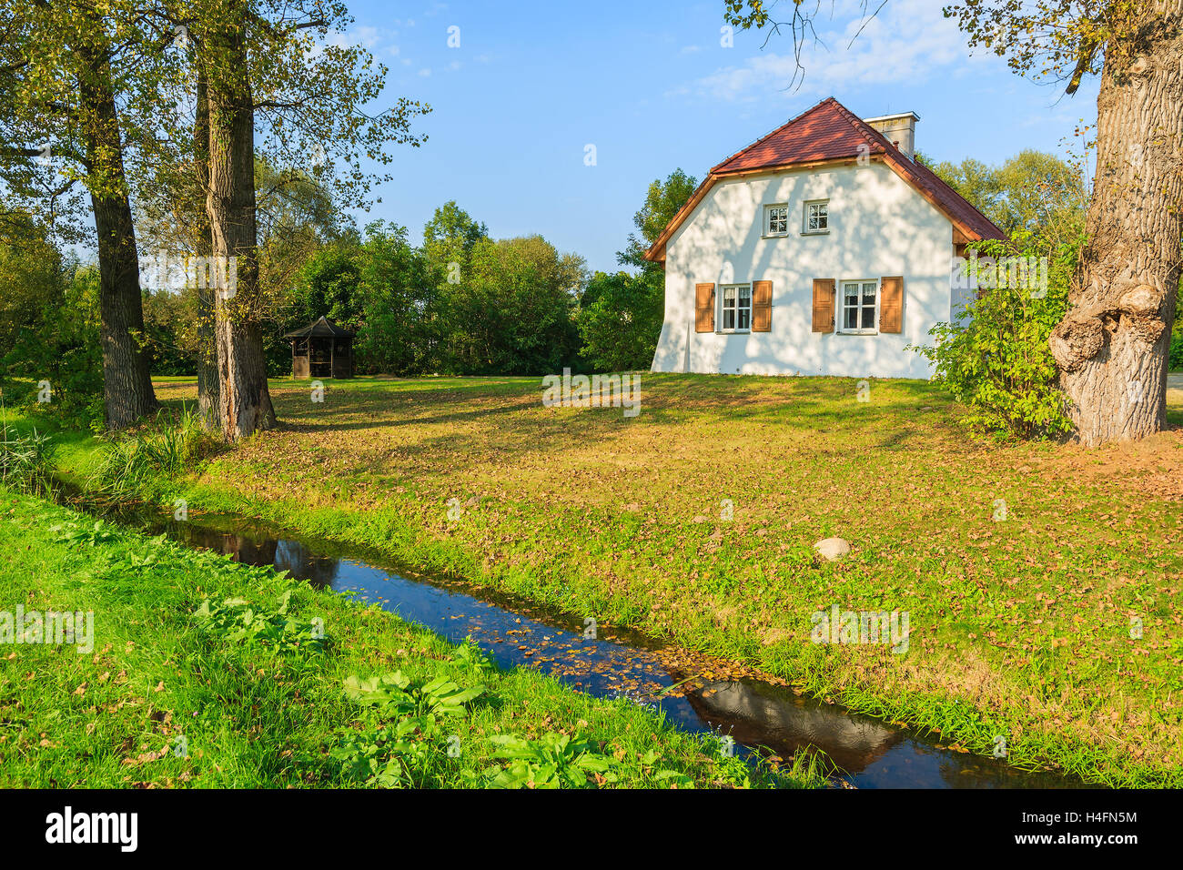 Tradizionale casa cottage e piccolo fiume nel paesaggio di campagna, Radziejowice village, Polonia Foto Stock