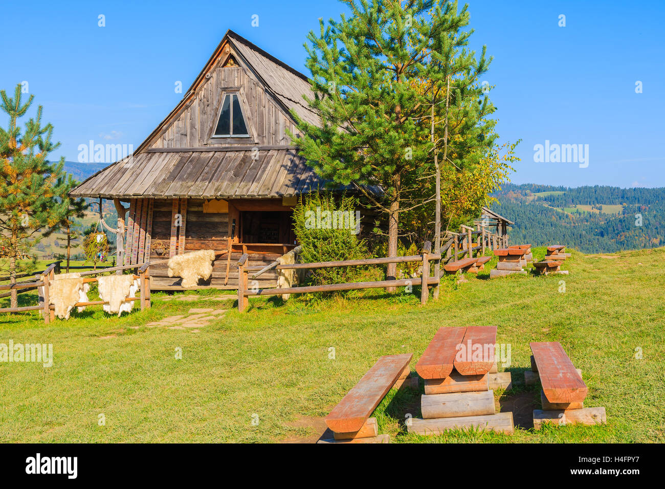 Panca su prato verde e pelliccia di pecora in vendita nella parte anteriore di una baita di montagna in Pieniny Mountains, Polonia Foto Stock