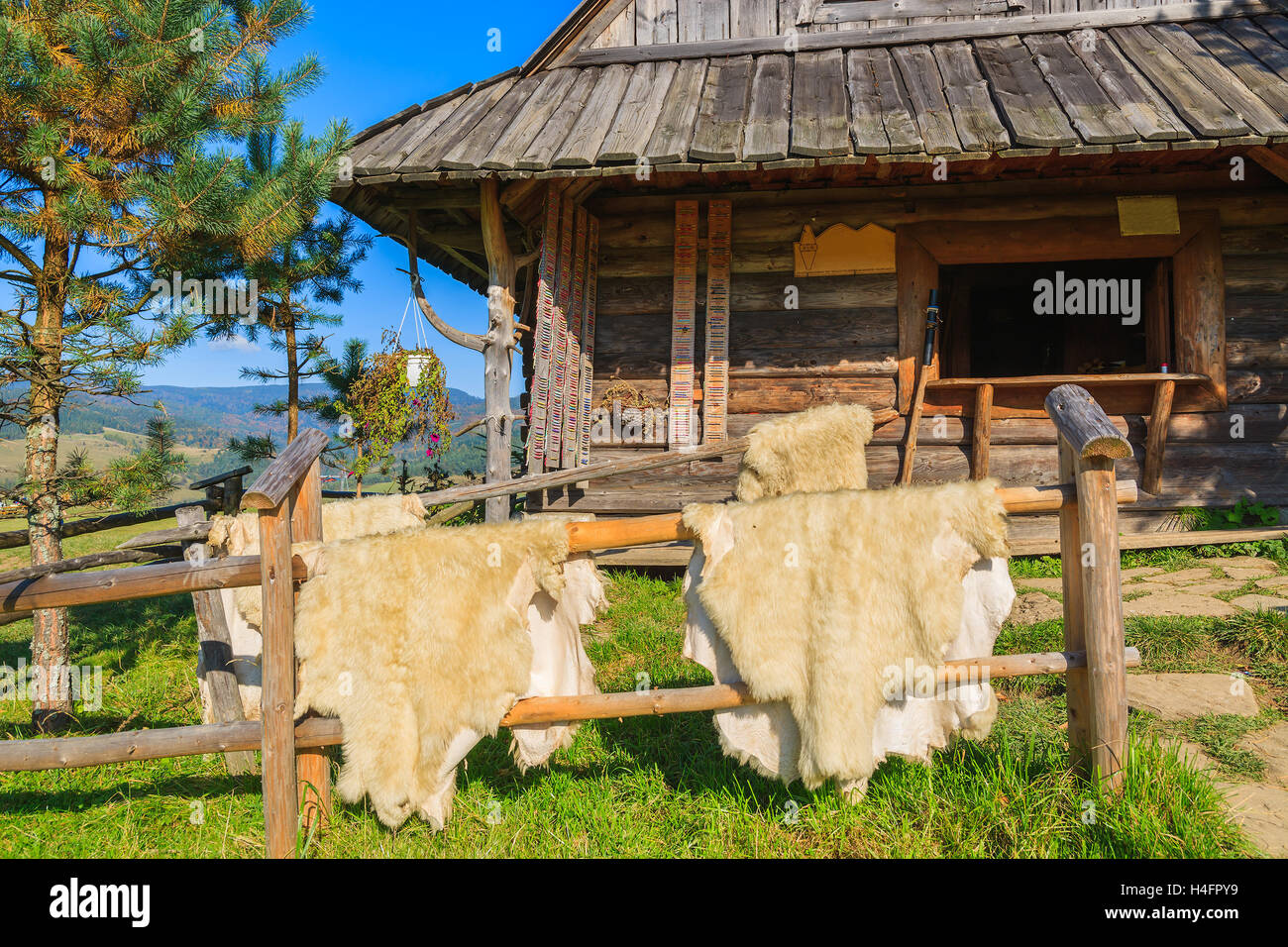 La pelliccia di pecora in vendita appeso alla recinzione di legno nella parte anteriore di una baita di montagna in Pieniny Mountains, Polonia Foto Stock