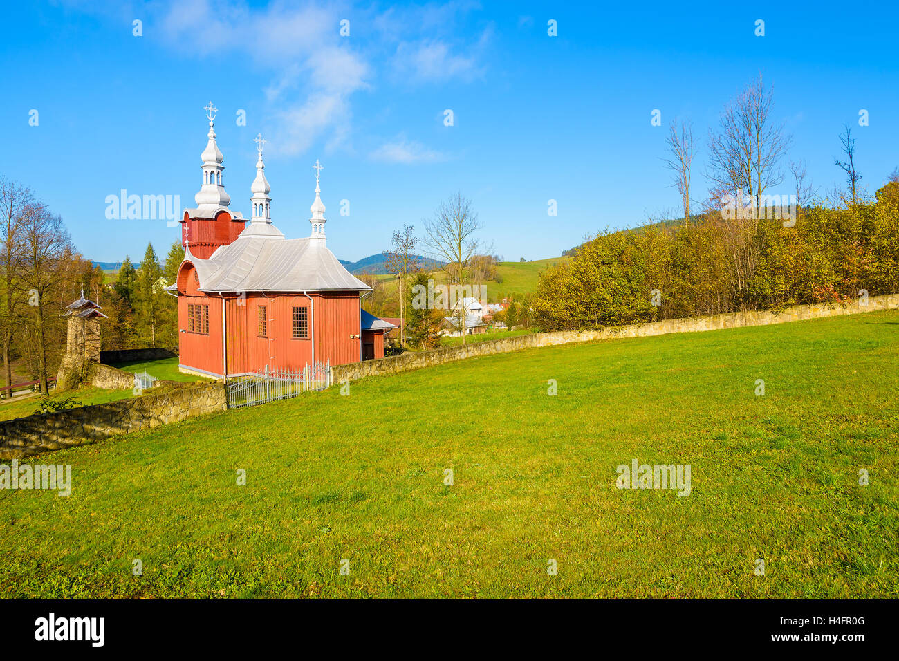 Rosso chiesa in legno sul prato verde nel villaggio Czyrna, Beskid Niski montagne, Polonia Foto Stock