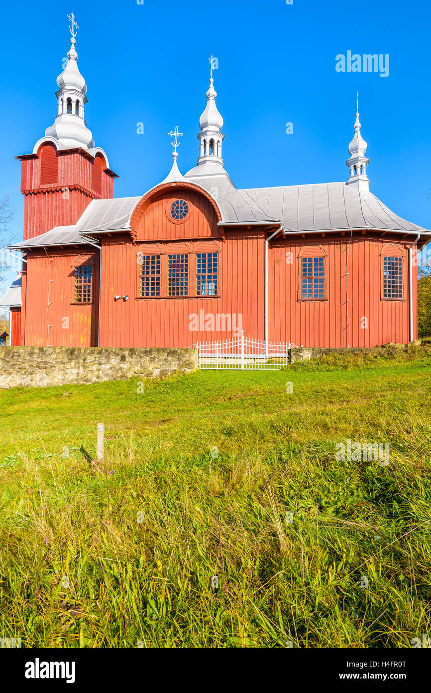 Rosso chiesa in legno sul prato verde nel villaggio Czyrna, Beskid Niski montagne, Polonia Foto Stock