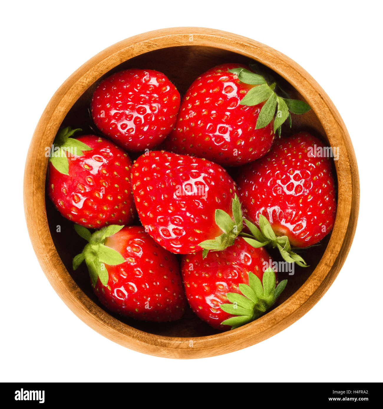 Giardino di fragole in una ciotola di legno su sfondo bianco. Fresche e mature rosso brillante frutti di Fragaria ananassa. Foto Stock