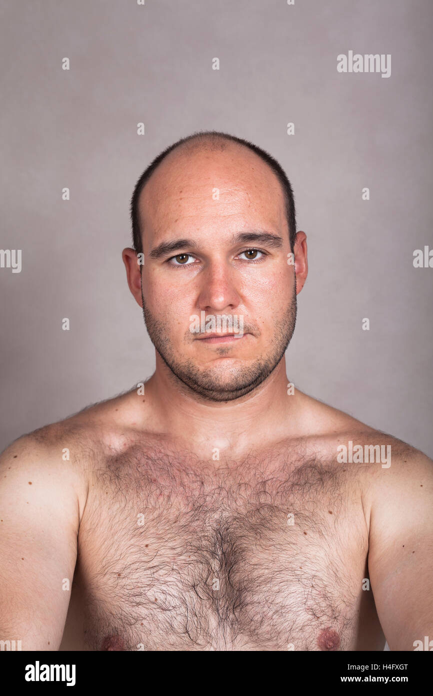 Ritratto di grave shirtless uomo che mostra il suo petto peloso. Foto Stock