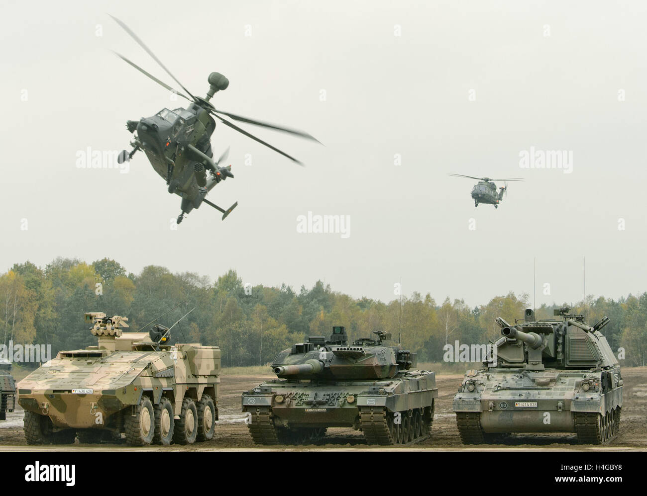 Munster, Germania. Xiv oct, 2016. Un elicottero di combattimento Tiger (l-r) e un elicottero multiuso NH90 volare attraverso un trasportatore di blindati veicolo (GTK) Boxer (l-r), un serbatoio di combattimento Leopard 2 e un obice blindato 2000 nel contesto dell'informativa pratica educativa " Land operations 2016' nella zona di addestramento militare nelle vicinanze Munster, Germania, 14 ottobre 2016. Insieme con l'olandese soldati delle forze armate tedesche pratica la cooperazione tra esercito, un servizio di ambulanza e unità della cosiddetta comune servizio di supporto dal 4 al 14 Ottobre. Foto: SEBASTIAN GOLLNOW/dpa/Alamy Live News Foto Stock