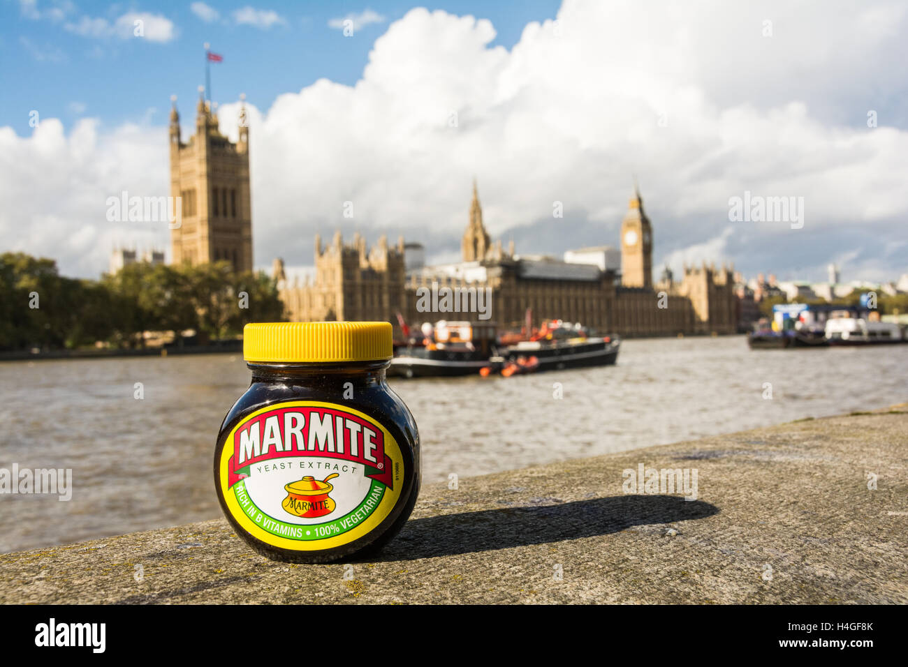 Primo piano di un barattolo di marmite sulle rive del Tamigi che si affaccia sulle camere del Parlamento Foto Stock